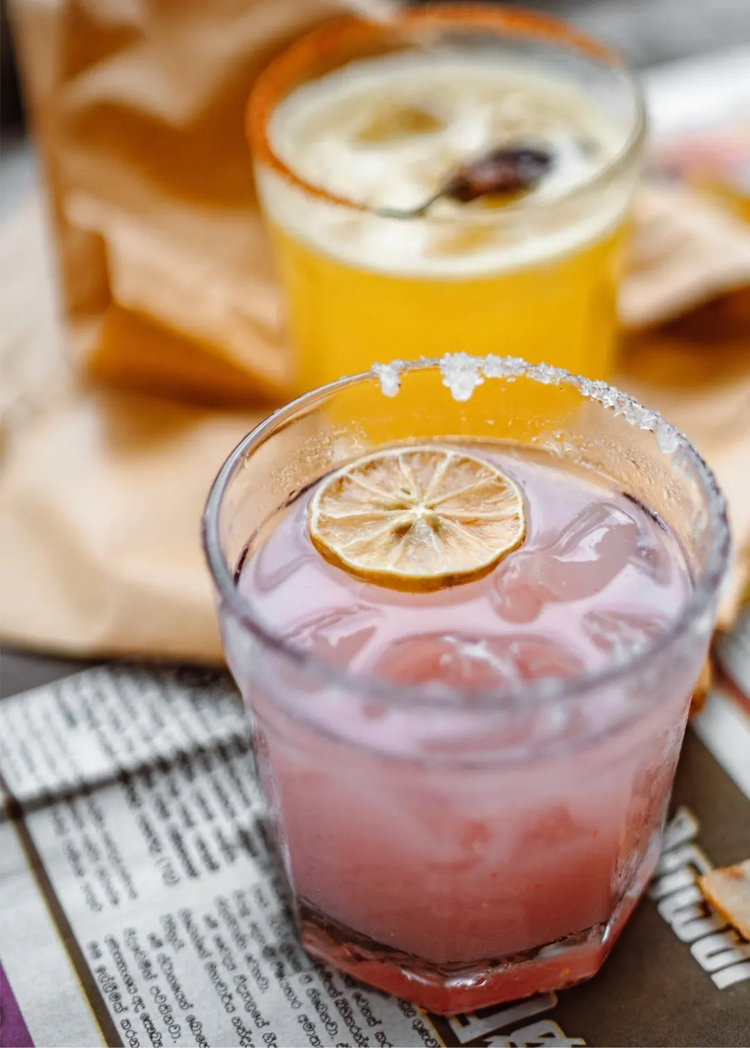 Two specialty drinks over clear gourmet cube ice