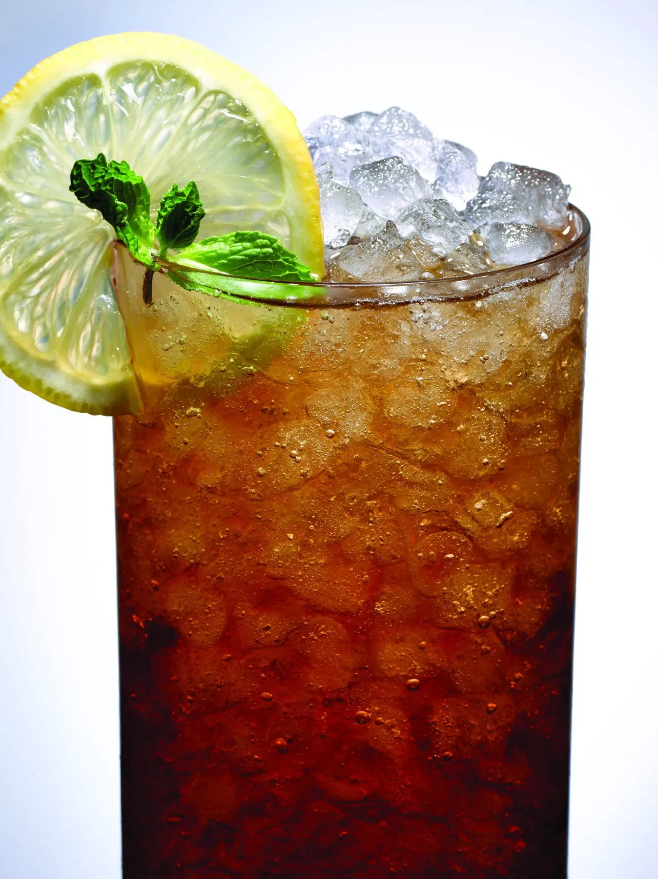 An iced tea packed with clear ice and a lemon wheel